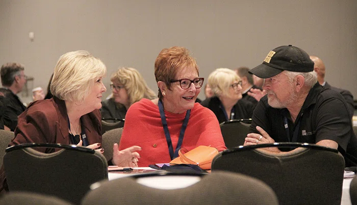Claudia Vicino, Mary Ann Sanders and Tom Teagle discuss a prompt during a keynote.
