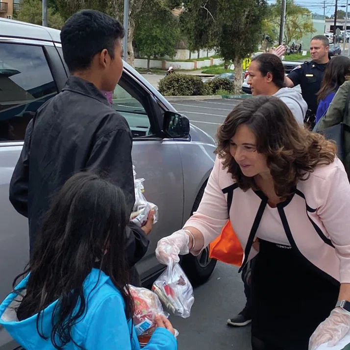 San Diego USD Superintendent Cindy Marten passes out free lunches to students.