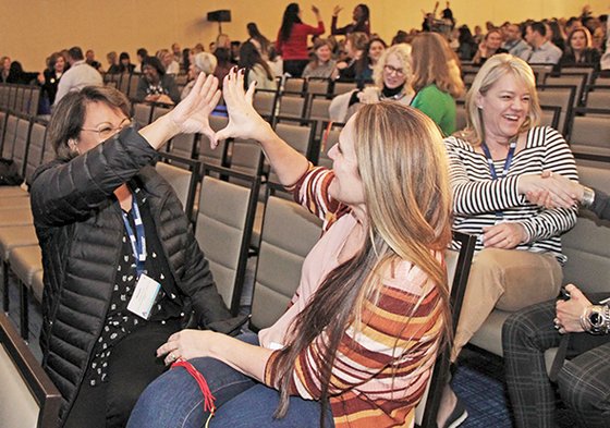 Attendees create their own handshakes as part of a keynote presentation by Derek Greenfield.