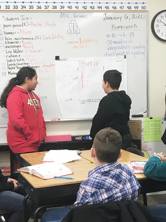 Sixth-graders at Robbins Elementary School work on a division problem.