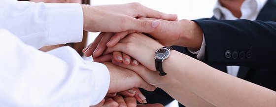 Hands piled together showing teamwork.