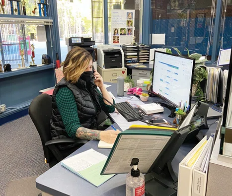 District staff member on the phone at her desk.