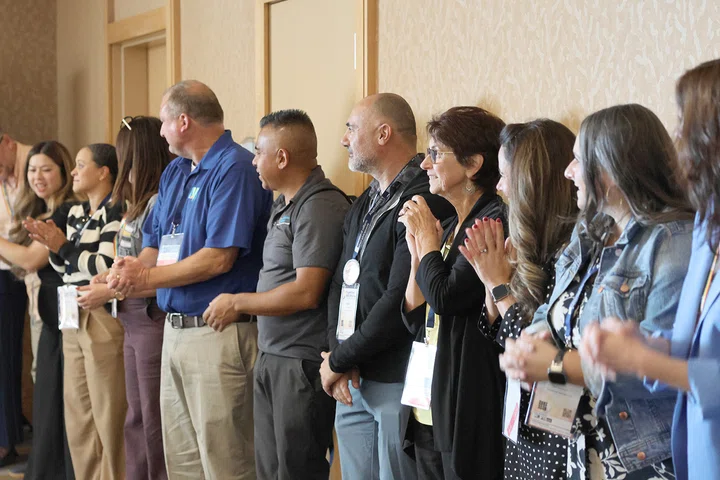 Attendees play a clapping game during a session on boosting staff morale.