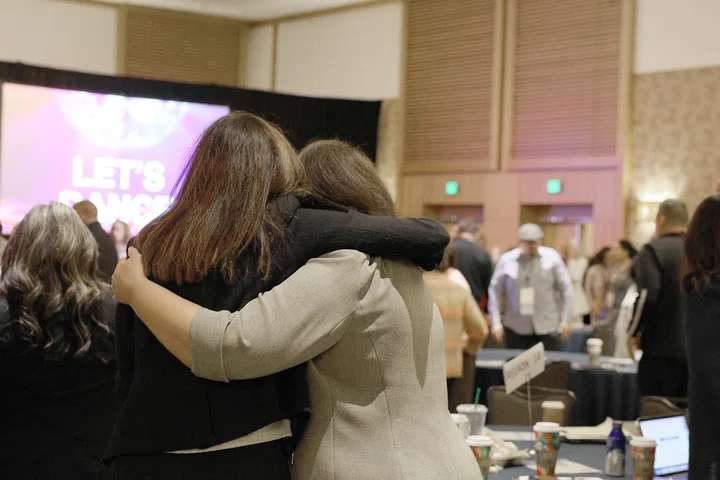 Attendees hug after dancing during Marlon Styles’ keynote.