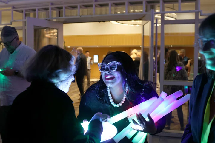 Patricia Brent-Sanco passes out glow sticks at the welcome reception.