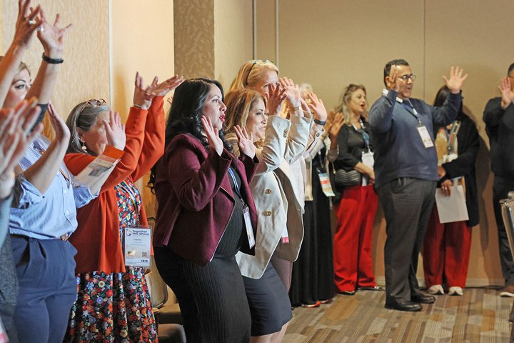 Attendees play a game and celebrate during a session on boosting staff morale.