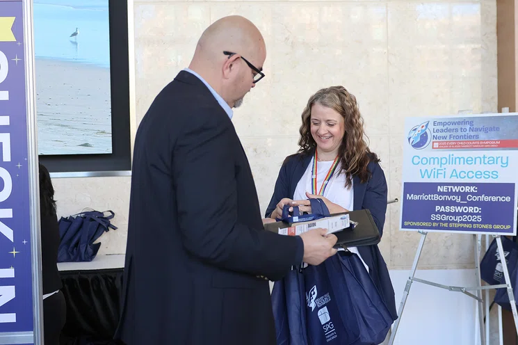 Planning Committee Member Jacqueline Willis hands bags to attendees as they check in.