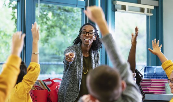 Teacher_in_Classroom_Raised_Hands.jpg