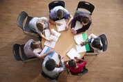 Team sitting around table working together.