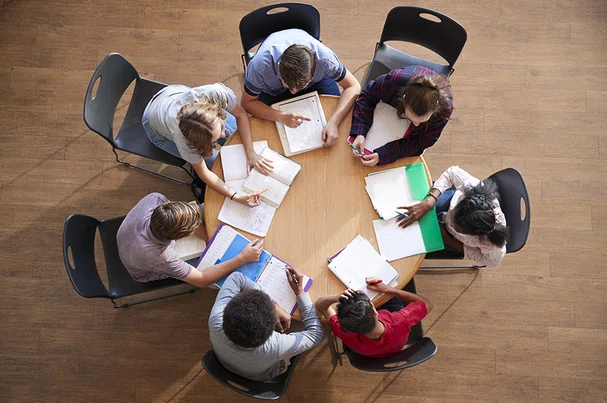 Team sitting around table working together.