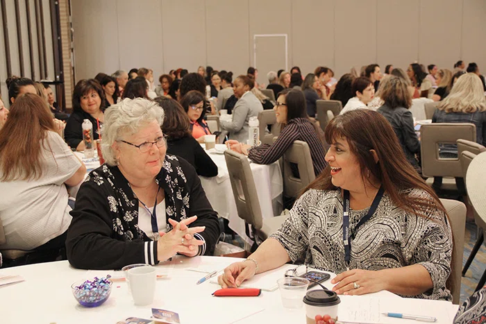 Attendees share experiences during a keynote session.