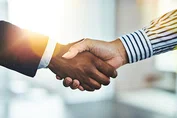 Hands shaking in business clothing.