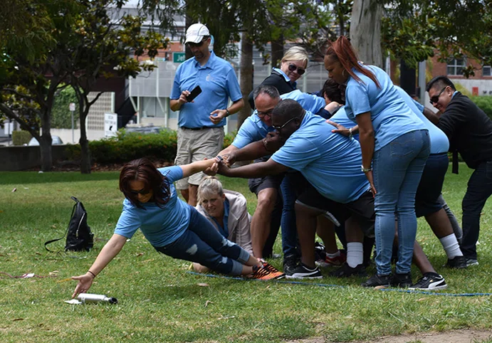 Principals work together to reach an object placed outside of a circle.