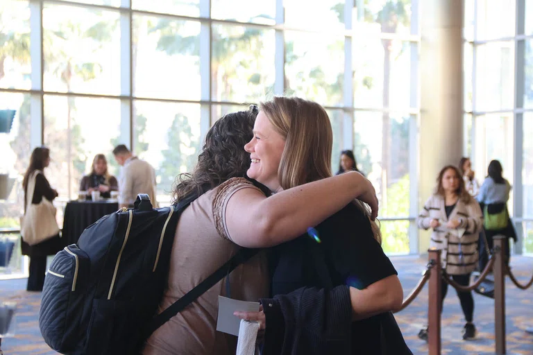 Attendees greet each other at the beginning of the conference.