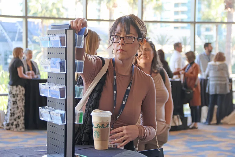 An attendee picks out a banner to attach to her conference badge.