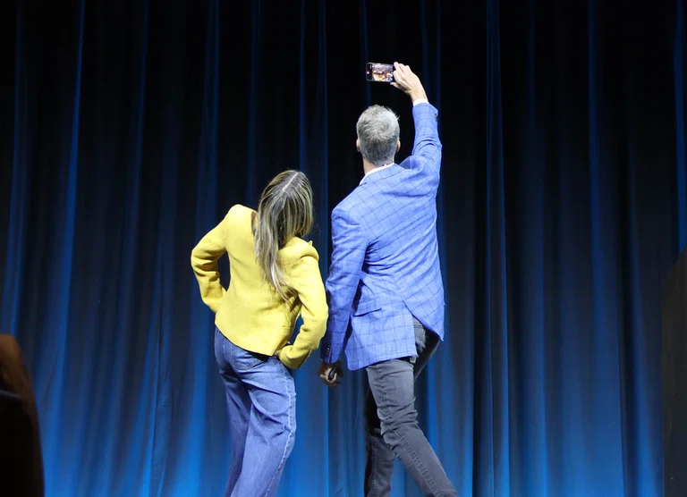 Keynote speakers Kim and Penn Holderness pause for a selfie from the stage.