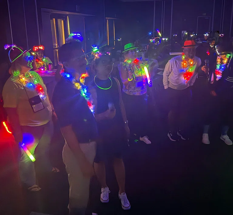 Attendees let their light shine during a glow party.