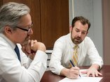 Two male professionals working at a table.