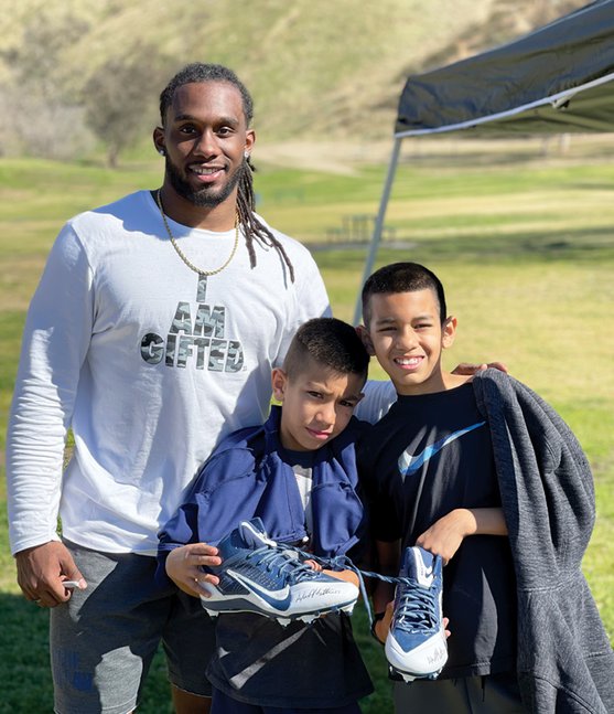 Alexander Mattison with two children at his youth camp.