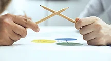 Two pencils held by hands, crossed like swords.