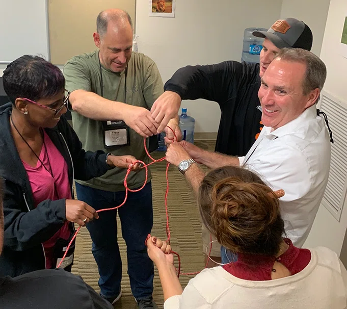 Principals work together to untie a knot.